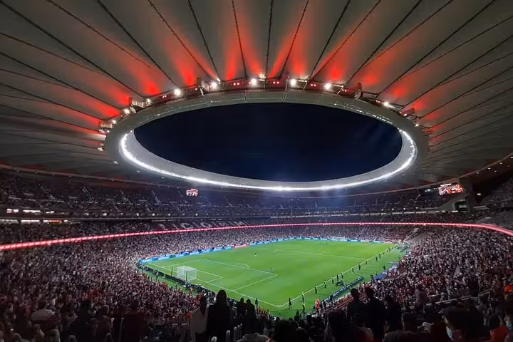 Packed Riyadh Air Metropolitano stadium at night during Atletico Madrid match, local fan game experience in Madrid