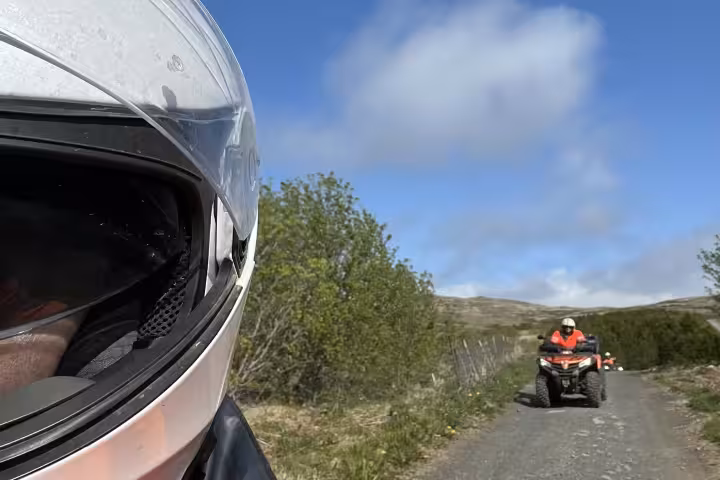 ATV rider wearing helmet leads thrilling quad bike adventure tour through scenic Reykjavik Iceland landscape.