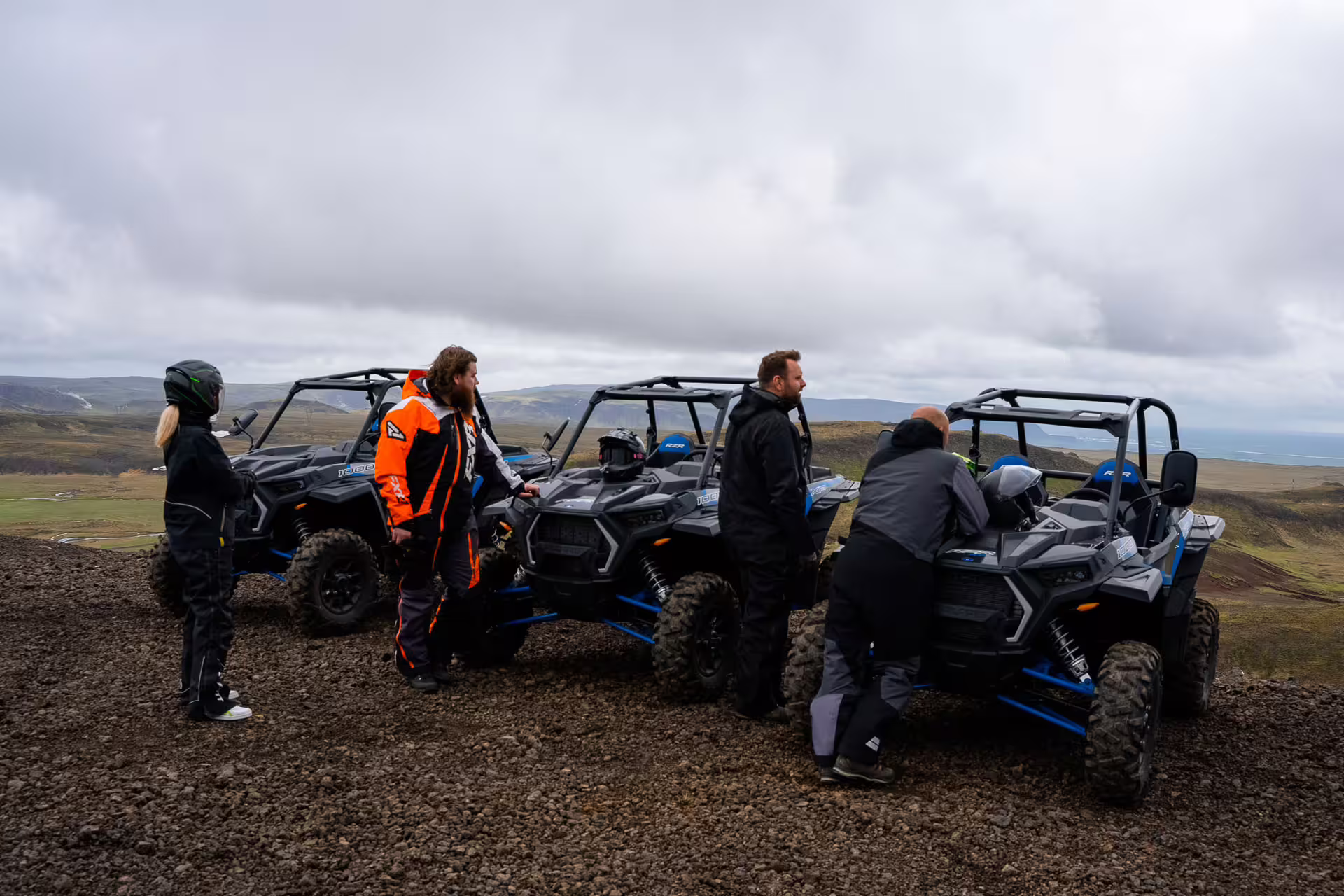 Group of tourists with Polaris RZR buggy ATVs on rocky highland terrain near Reykjavik, Iceland