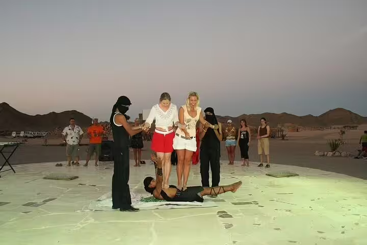 Guests join Bedouin show games during desert dinner after ATV quad biking and camel ride in Marsa Alam