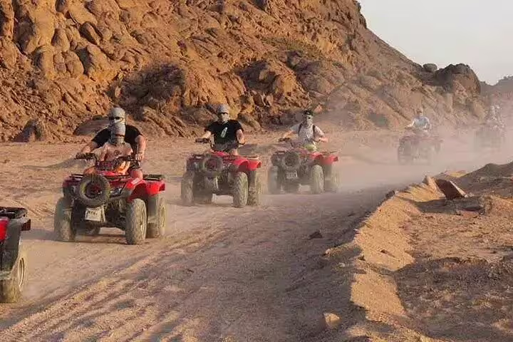 Group riding ATVs through Sinai desert trails on a private quad bike safari tour from Sharm El Sheikh