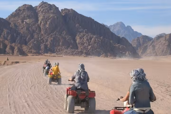 Super Safari quad ride near Sharm El Sheikh, group driving across Sinai sands with rugged mountains backdrop