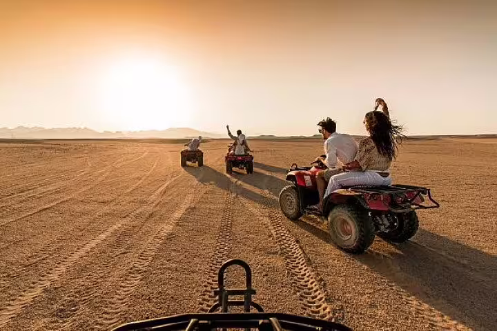 ATV convoy crossing Sinai Desert at golden hour on private quad bike safari adventure from Sharm El Sheikh