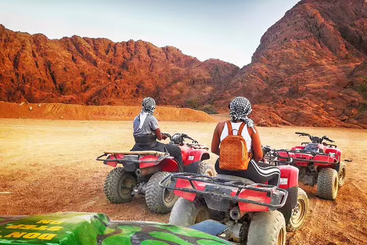 ATV quad bikes parked in Hurghada desert canyon, riders in headscarves on Red Sea safari adventure tour