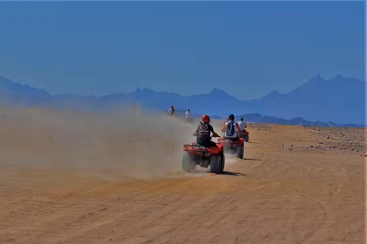 ATV quad biking across Sinai desert dunes near Sharm El Sheikh on Mega Safari Waves and Dunes trip