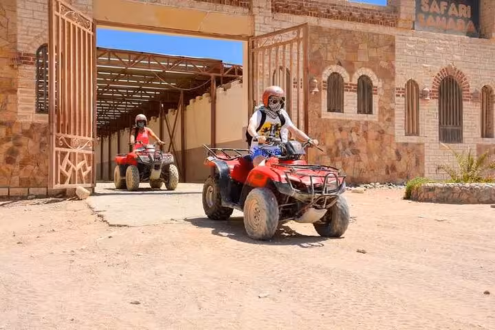 ATV quad riders leaving safari camp gate on 5-hour desert super safari with buggy, BBQ dinner and show