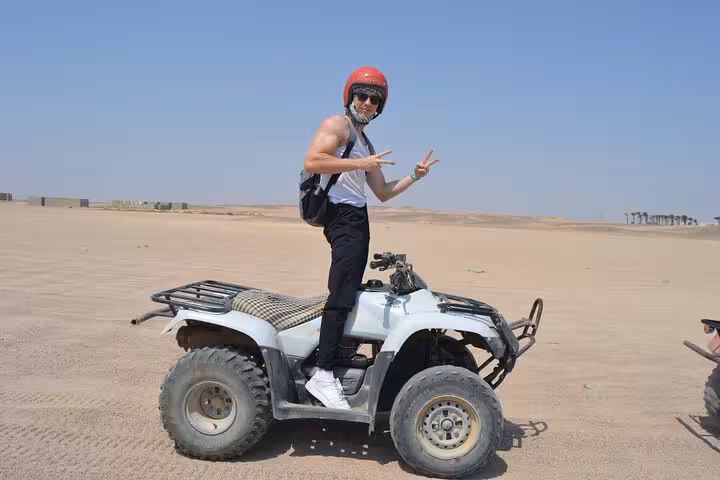Rider posing on ATV quad in Sharm El Sheikh desert, Red Sea dunes sunrise or sunset adventure tour