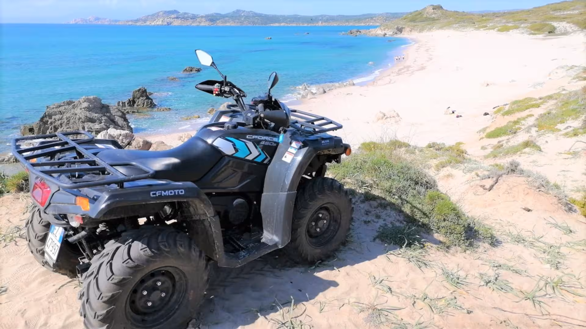 ATV parked on sandy cliff with stunning beach views, highlighting Santa Teresa di Gallura's thrilling 3-hour tour.
