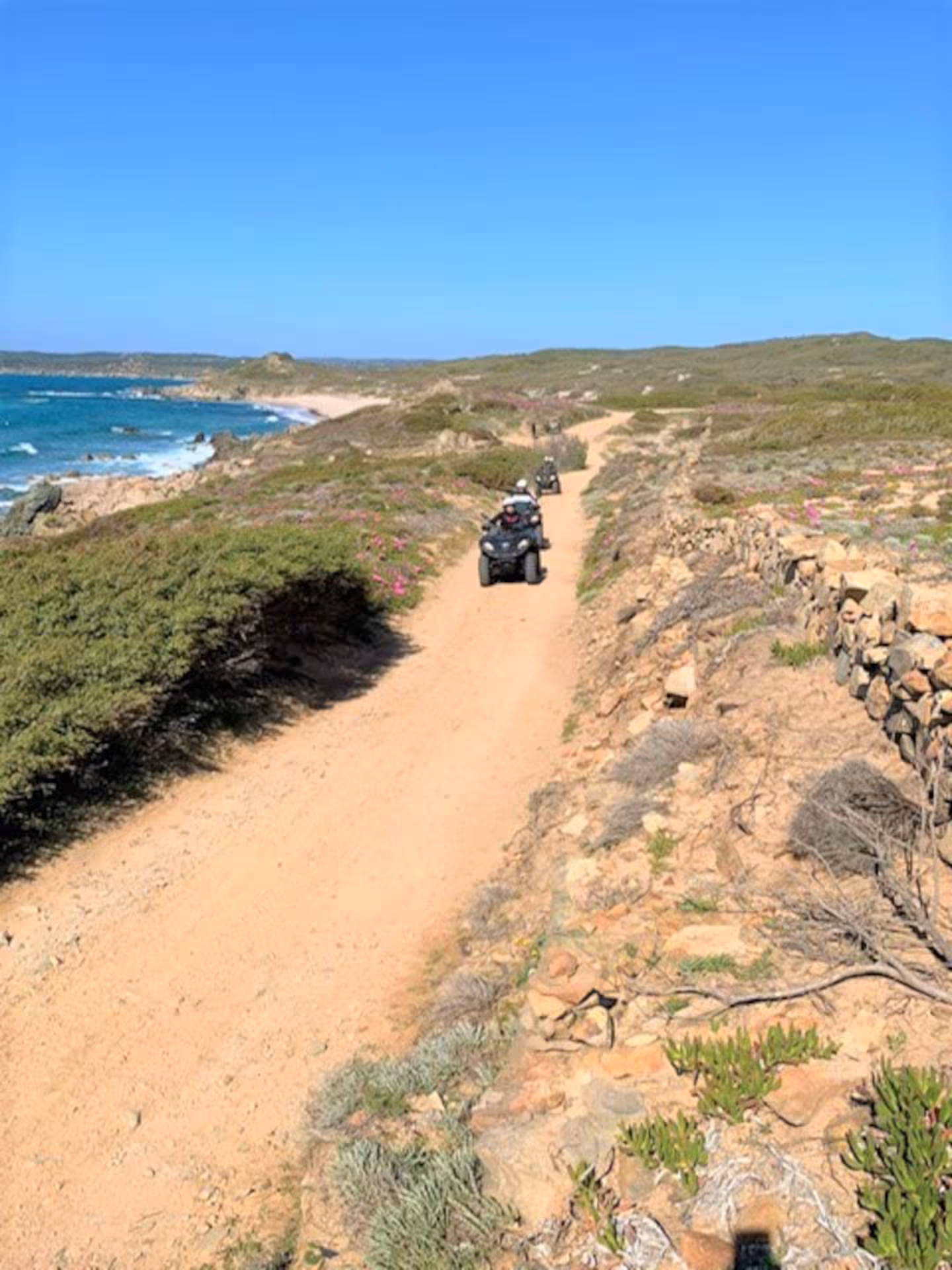 ATVs traversing a coastal path in Santa Teresa di Gallura, offering breathtaking views of the sea and landscape.