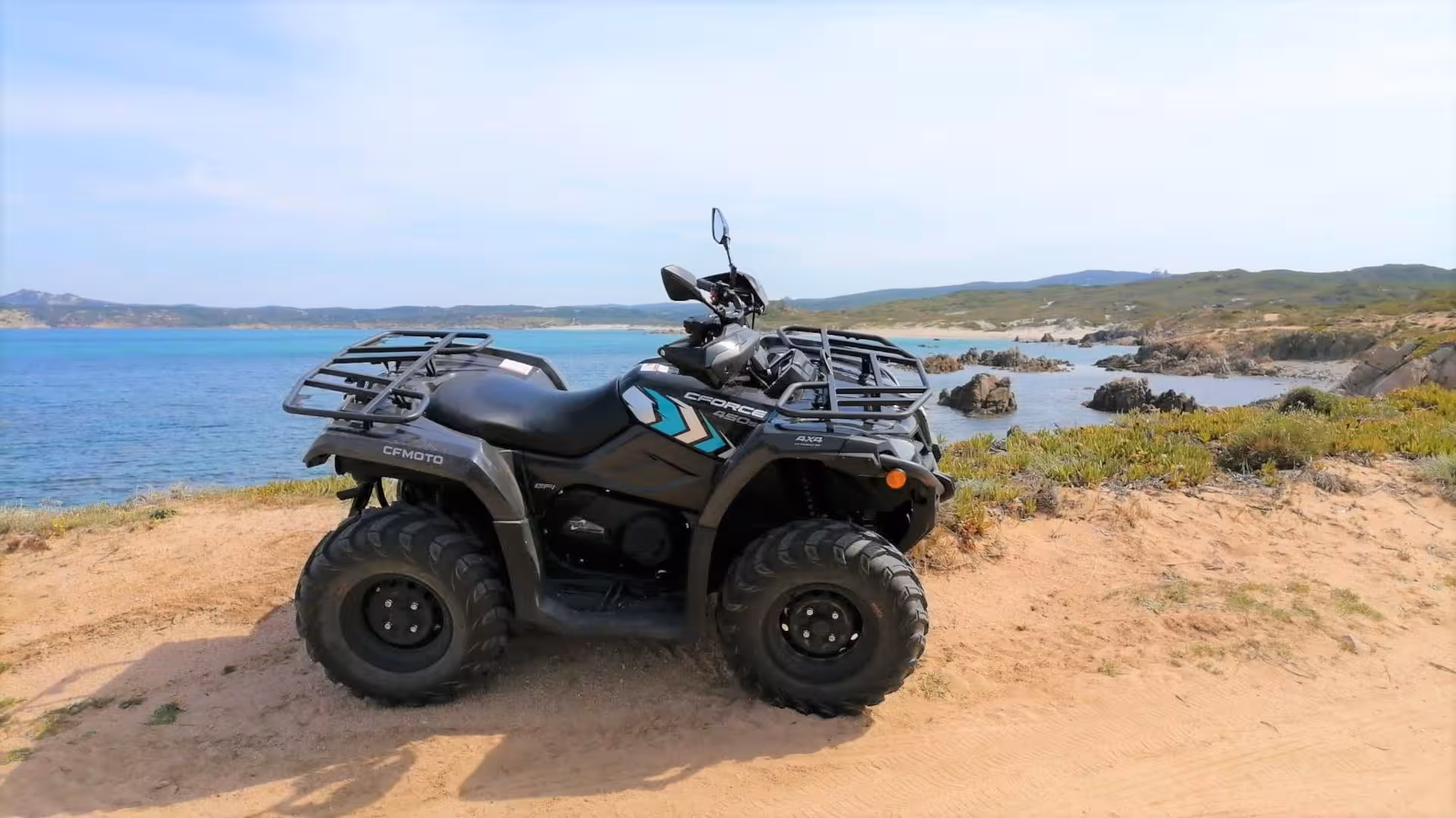 ATV parked on a sandy path overlooking the stunning coastal landscape of Santa Teresa di Gallura.