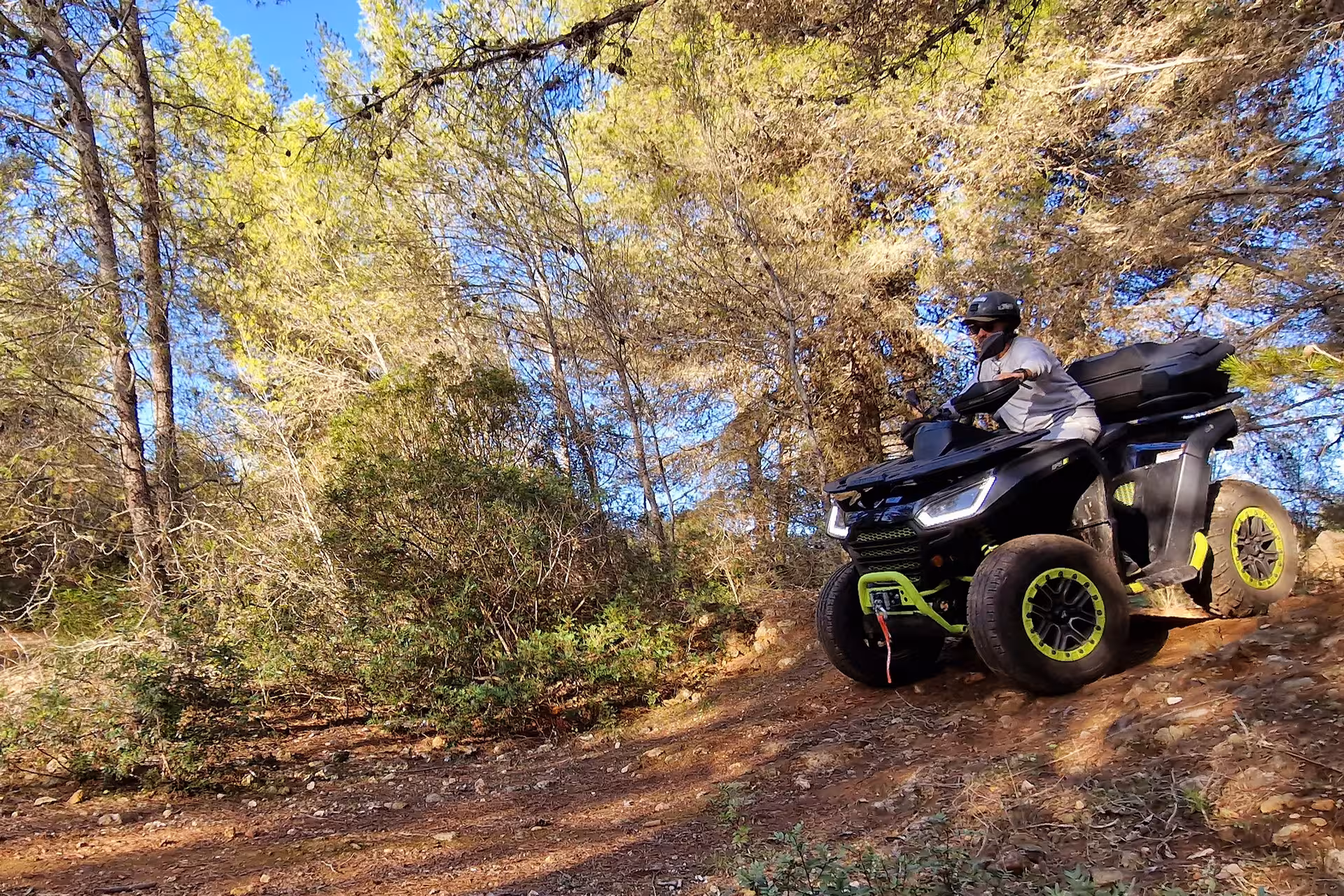 Adventurer rides an ATV through lush forest trails during the seven Hanging Valleys tour, capturing the thrill of the journey.