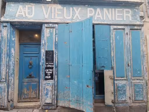 Weathered blue Au Vieux Panier storefront in Marseille, a charming stop on a 7-day Provence Christian heritage tour