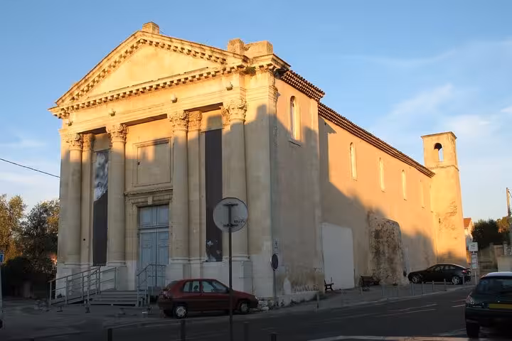 Neoclassical church facade with columns in Aubagne, France, bathed in golden evening light