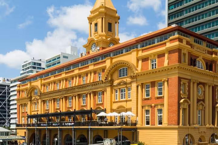 Historic yellow Ferry Building with clock tower in Auckland city waterfront
