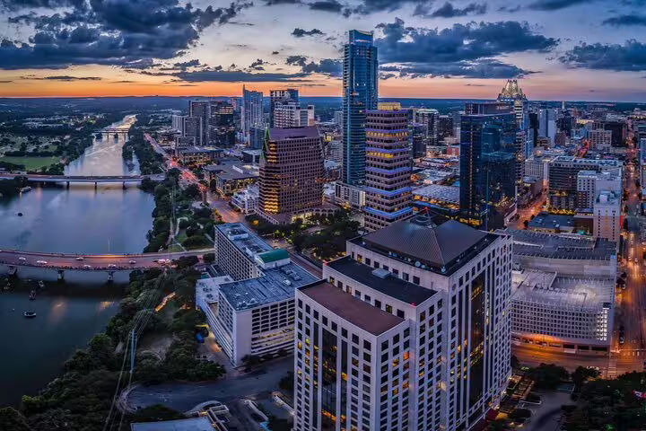 Aerial view of Austin Texas downtown skyline at dusk with Colorado River and city lights