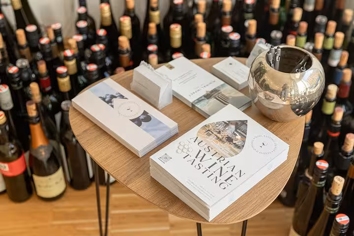 Austrian wine tasting booklets on a table surrounded by bottles, ideal for Vienna wine tour booking