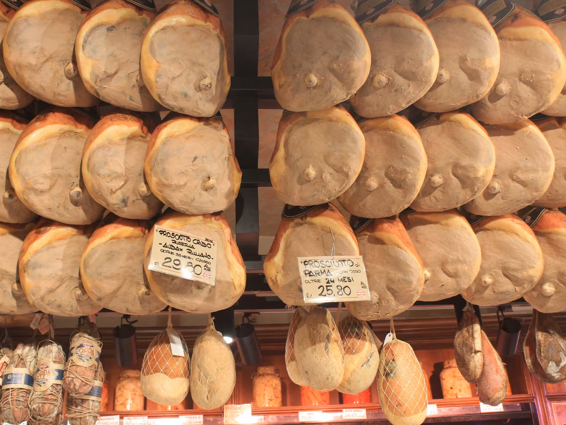 Display of authentic Parma prosciutto in a local shop, highlighting the rich culinary heritage of the region.