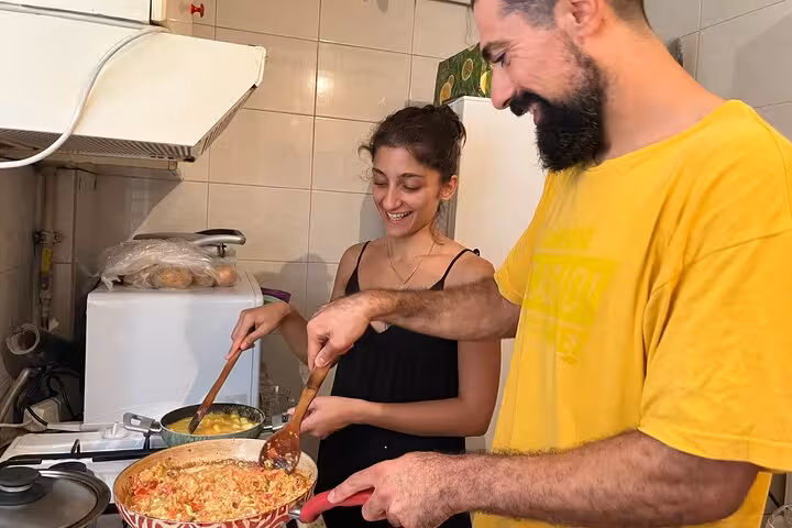 Local friends cooking menemen and eggs in a home kitchen during an authentic Turkish breakfast cooking class