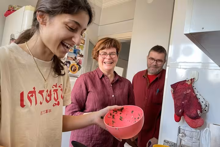 Smiling travelers mixing fresh herbs for authentic homemade Turkish breakfast with local friends cooking experience
