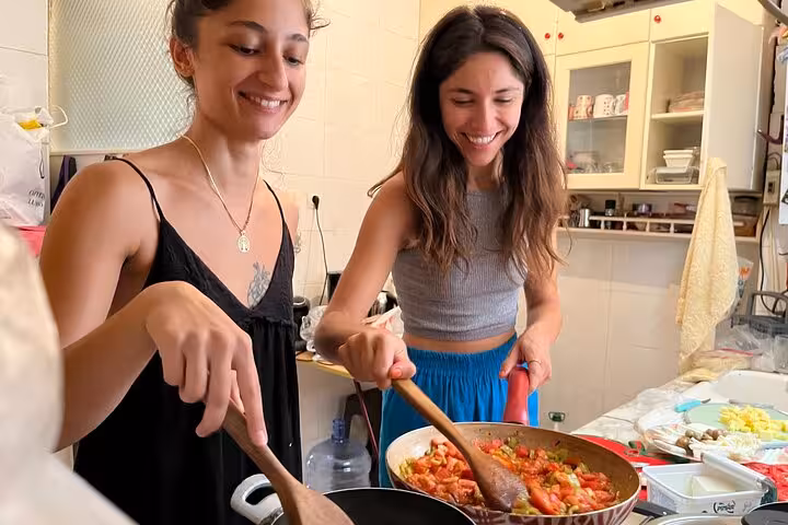 Travelers cooking menemen in a local kitchen during an authentic homemade Turkish breakfast class with local friends