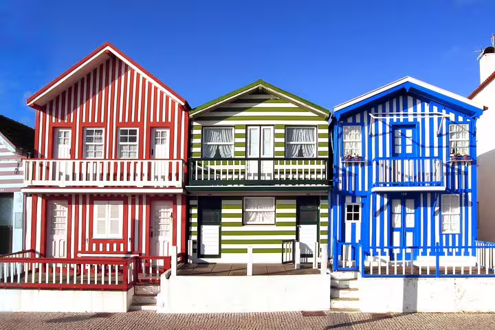 Colorful striped houses in Costa Nova, Aveiro, feature vibrant facades ideal for cultural half-day tours and boat rides.