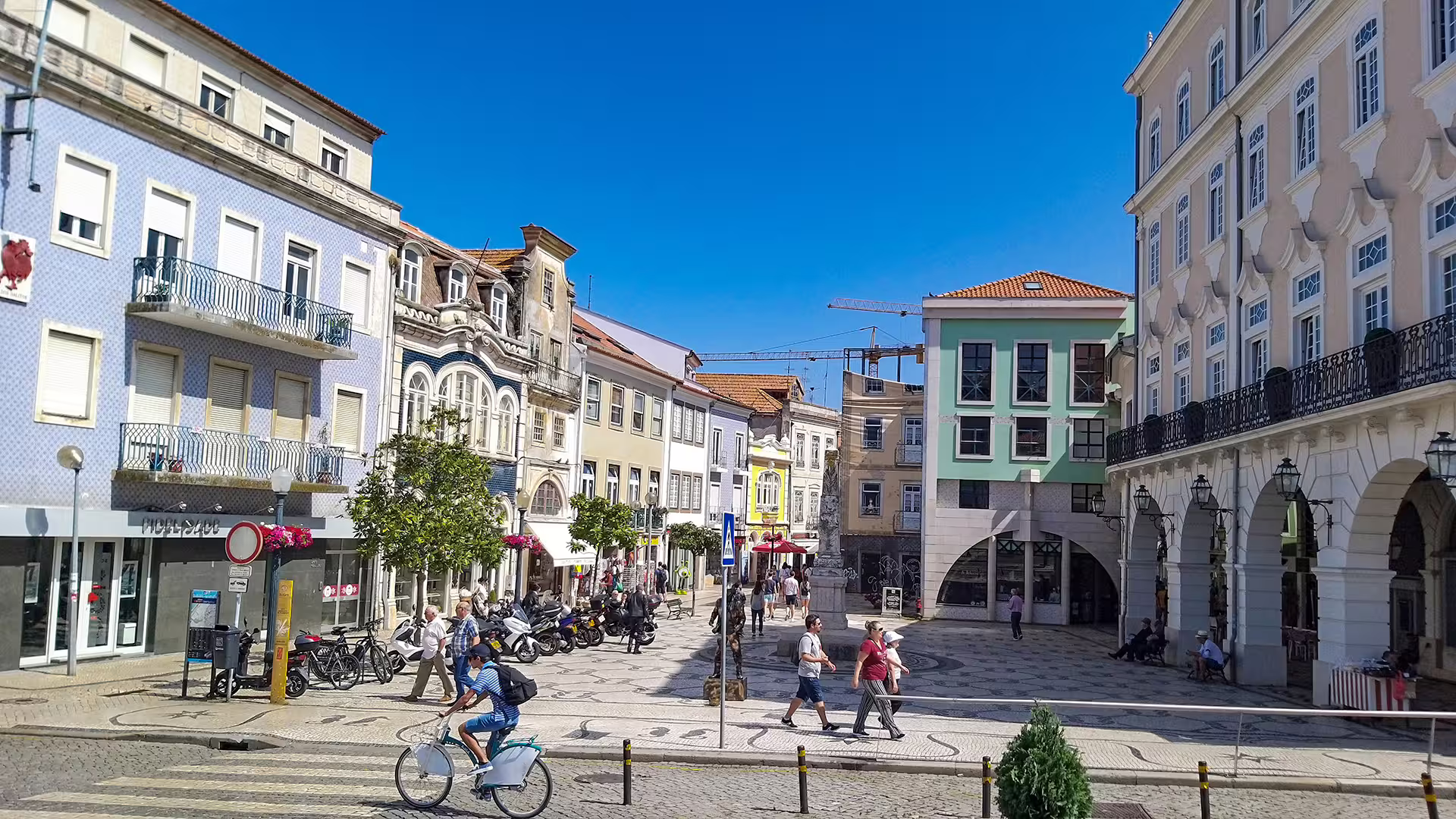 Vibrant street scene in Aveiro with charming architecture and visitors, perfect for a private tour to Costa Nova's striped houses.