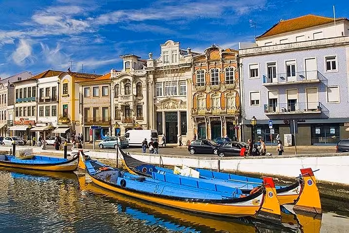 Aveiro canal with colorful moliceiro boats and Art Nouveau facades, popular stop on Lisbon Porto transfer tour