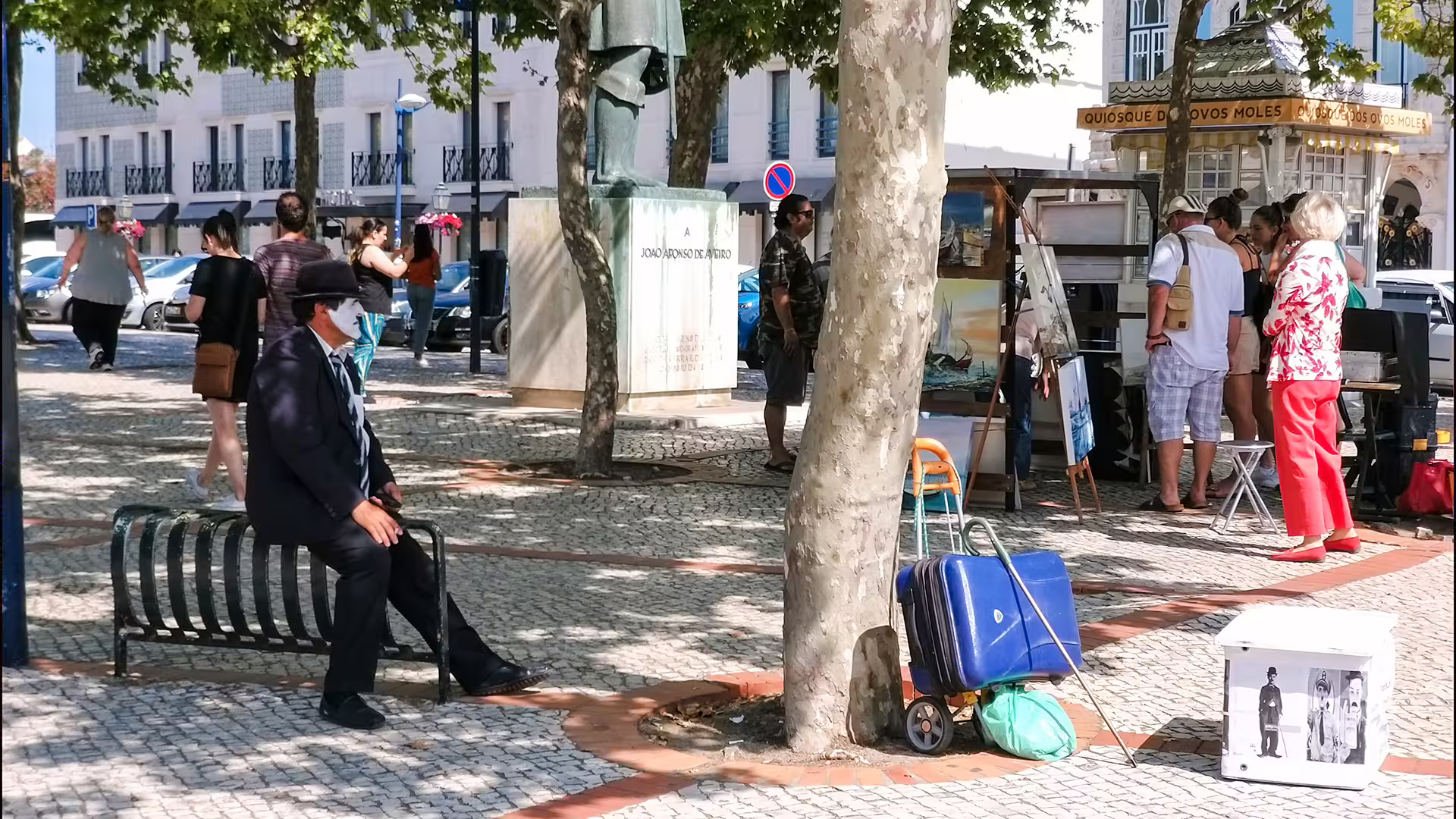 Street scene in Aveiro with local art, a mime performer, and tourists exploring, highlighting cultural charm and vibrant atmosphere.
