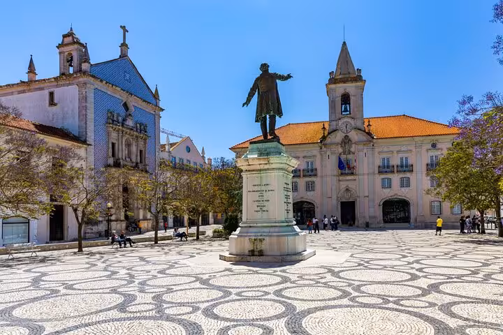 Aveiro main square with bronze statue, azulejo-covered church, and City Hall under blue sky