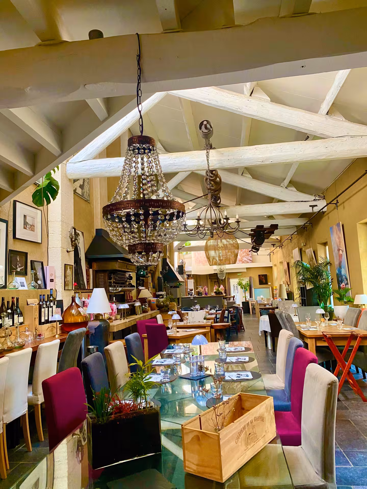 Elegant Avignon cooking workshop venue with rustic beams, chandeliers and set dining tables in Provence