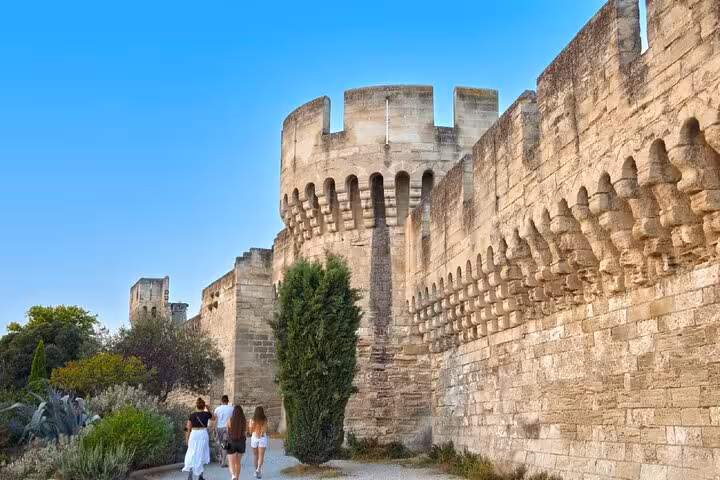Tourists walking along the medieval ramparts and tower walls of Avignon, France