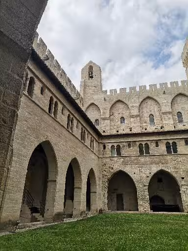 Avignon Papal Palace courtyard arches and stone walls, Provence Christian heritage cultural tour