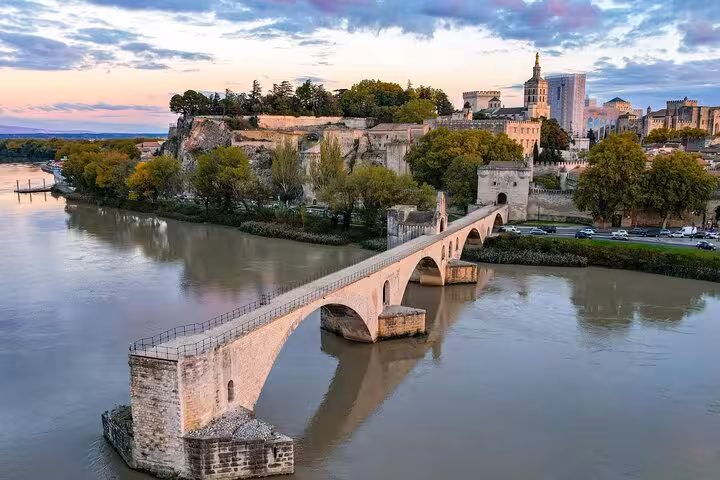 Pont Saint-Bénézet bridge over the Rhône River with Avignon's historic papal palace at sunset