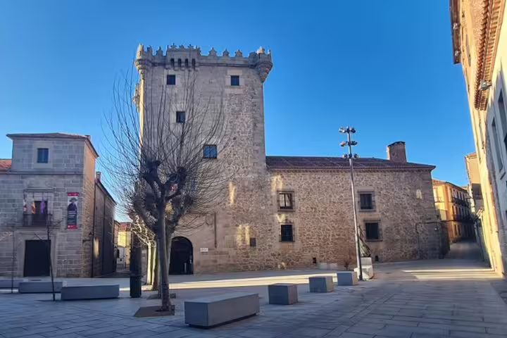 Medieval stone tower in Ávila old town square, sightseeing on Ávila and Segovia private minivan tour from Madrid