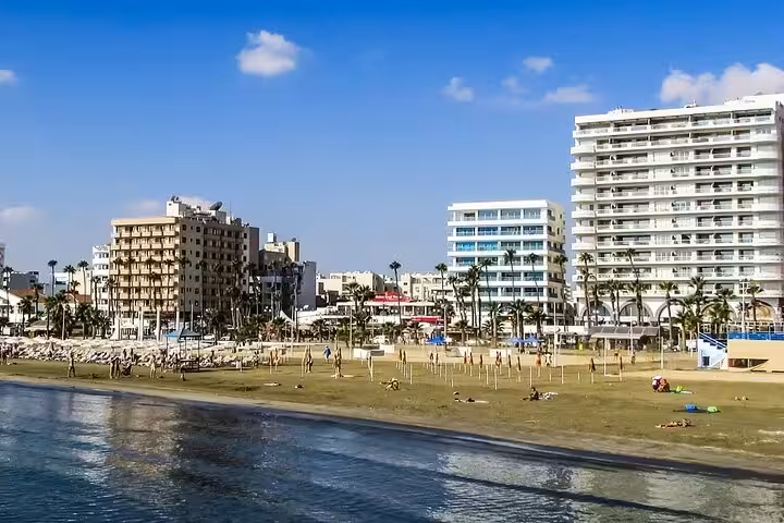 Ayia Napa beachfront promenade with hotels and sandy shore, stop on half-day tour from Larnaca to Cape Greco