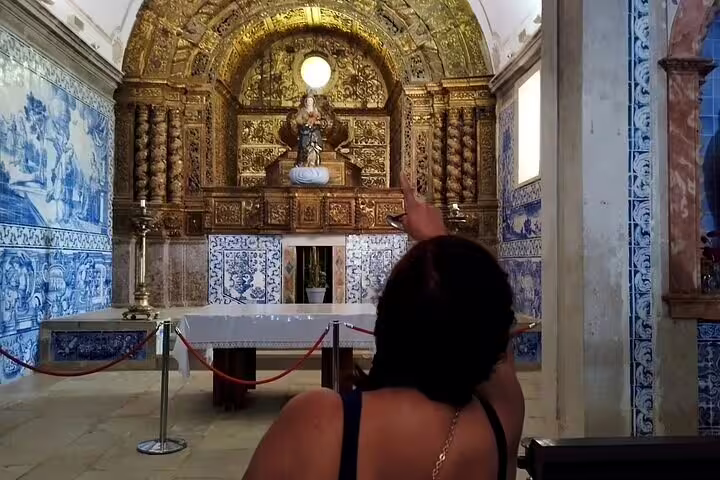 Visitor admiring intricate azulejos and ornate altar during Azeitão cheese workshop, wine tasting, and Sesimbra tour.