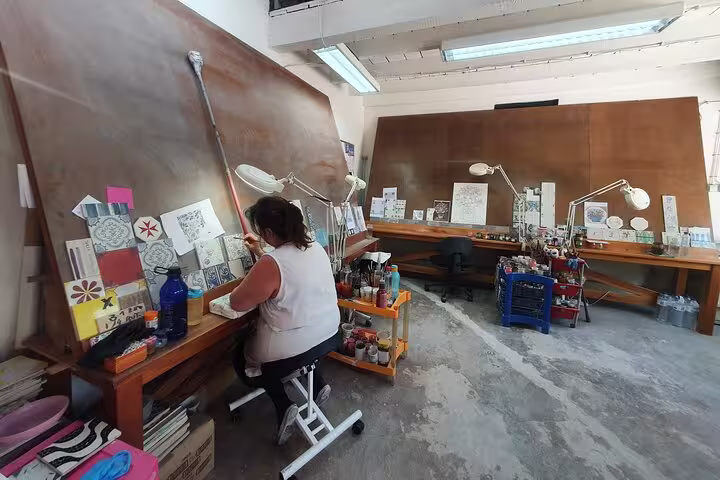 Artist painting traditional tiles in Azeitão studio, a cultural stop on the Arrábida and Setúbal private tour.