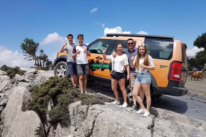 Group of tourists with an adventure jeep on rocky terrain, exploring the scenic Azoria region near Crete's North Coast.