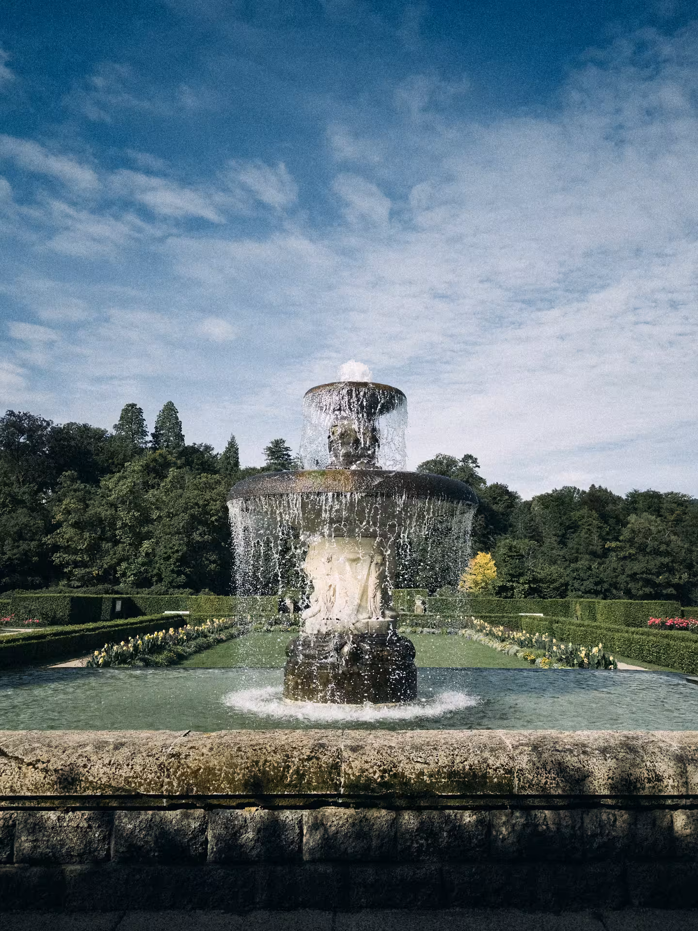 Ornate multi-tiered stone fountain with cascading water in a formal garden, Baden-Baden