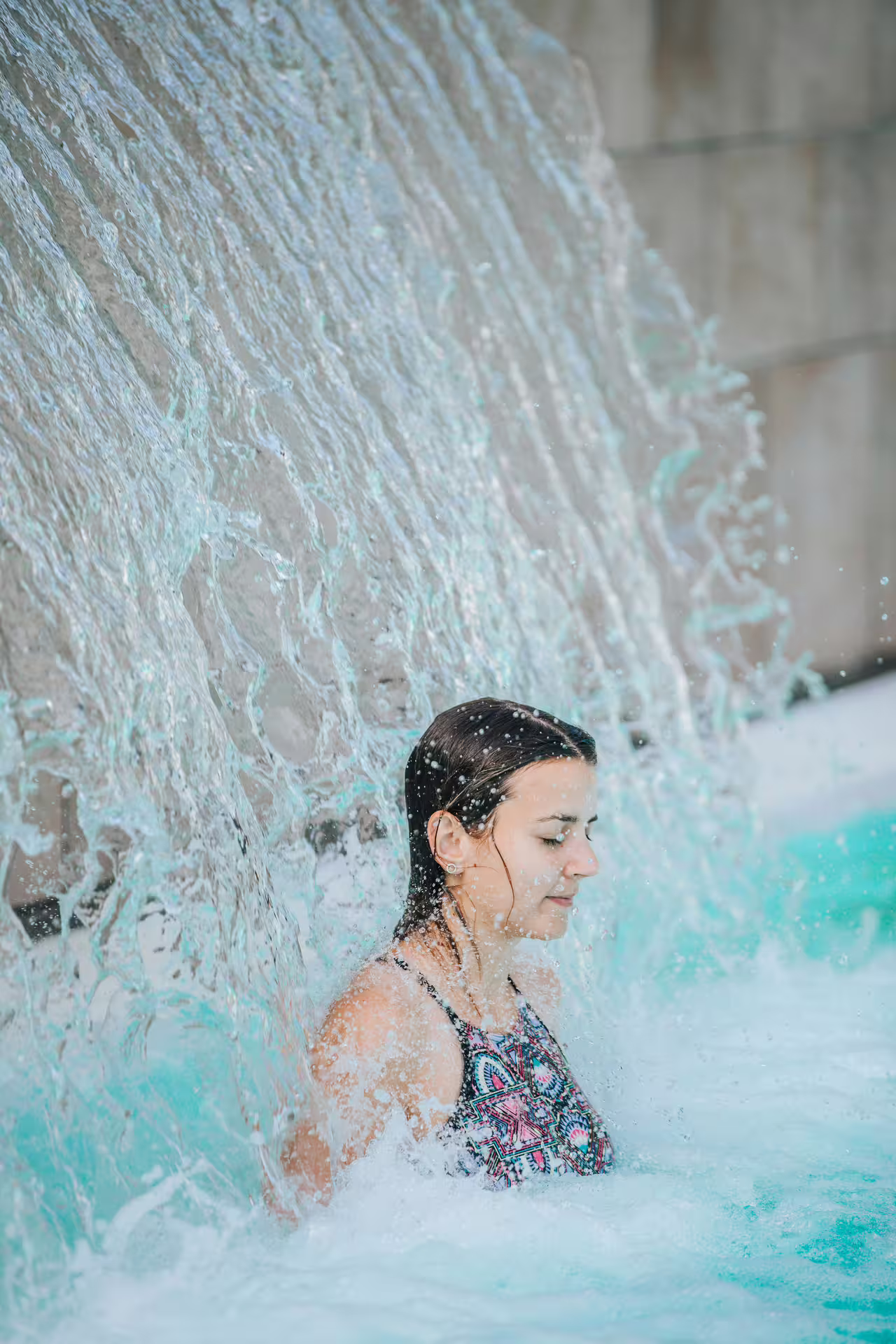 Woman enjoying waterfall hydrotherapy in Bagno di Romagna thermal pool, 2-hour spa entry and relax