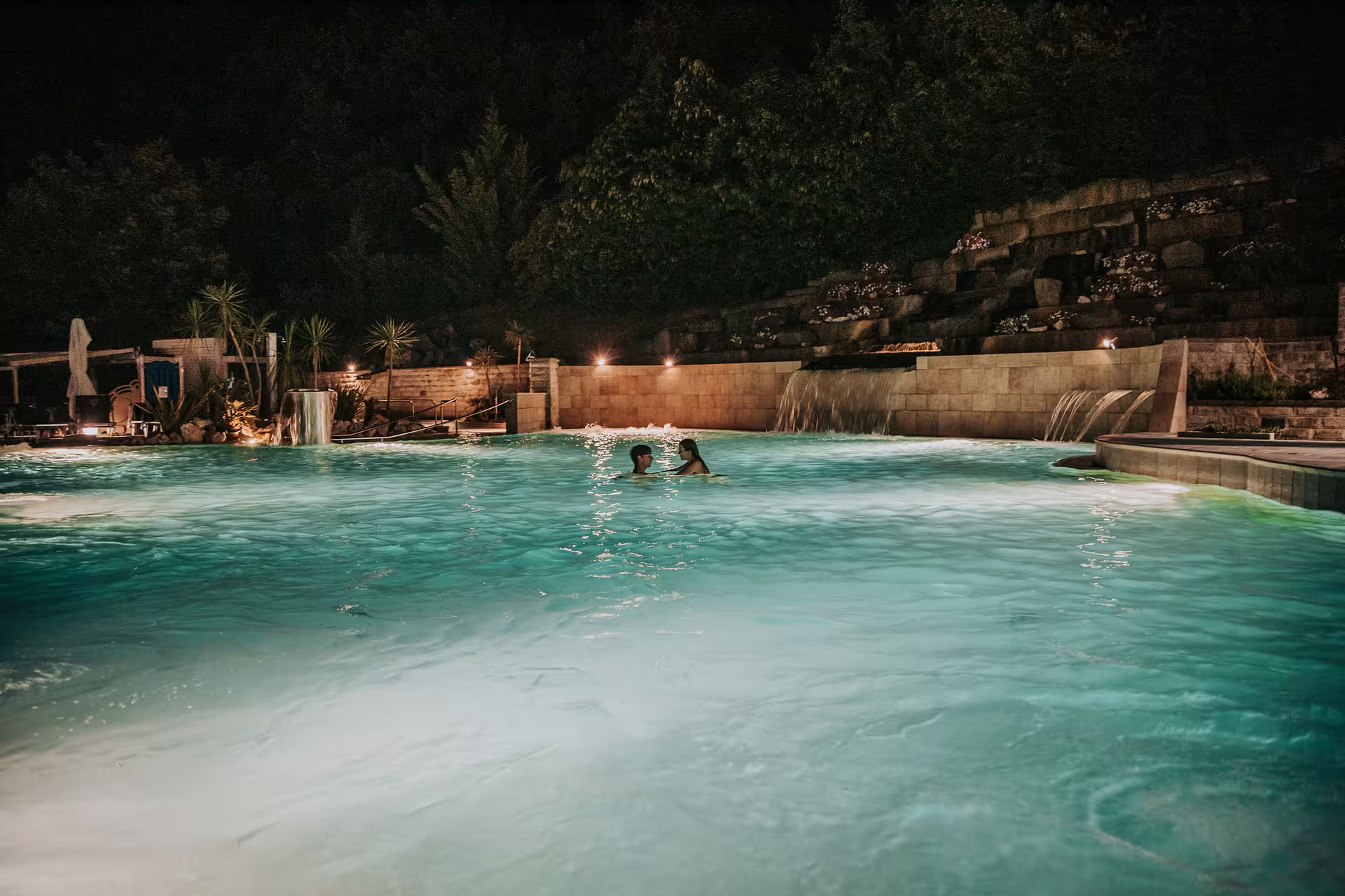 Night view of Bagno di Romagna thermal pool with waterfalls, ideal for 2-hour entry and aperitif experience