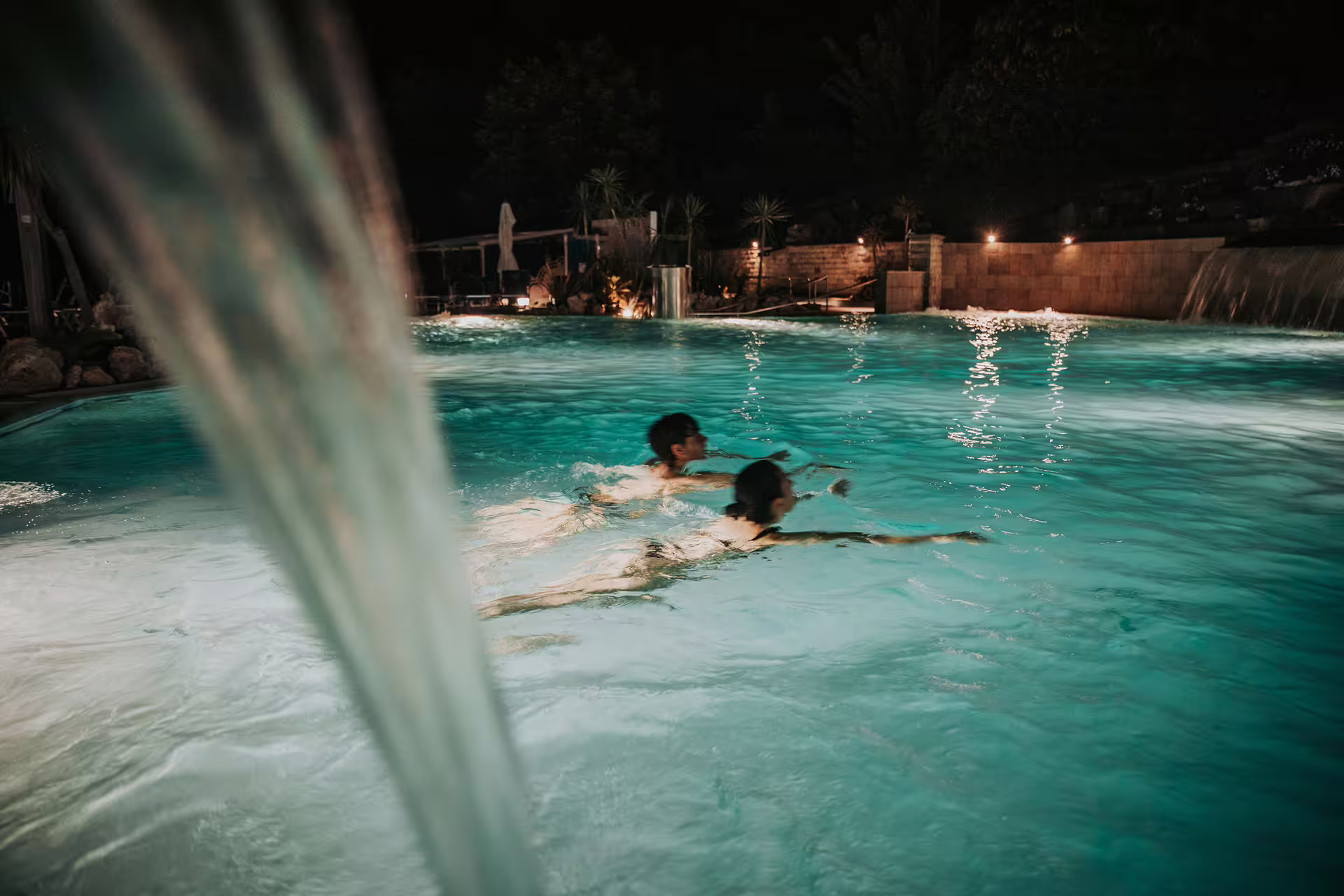 Night swim in Bagno di Romagna thermal pool with waterfall jets, part of spa entry with lunch and massage