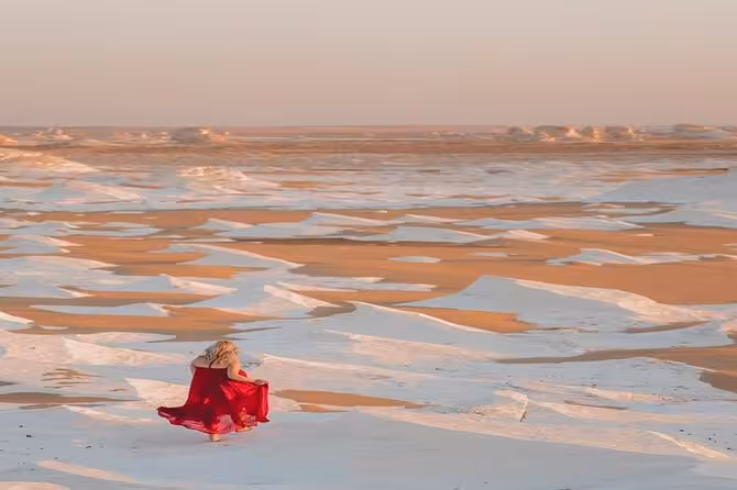 Traveler in red dress on White Desert sands, Bahariya Oasis 2-day camp and desert tour from Cairo