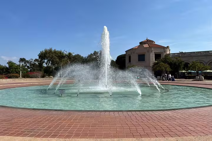 Ornate fountain at Balboa Park with Spanish Colonial building and blue sky in San Diego