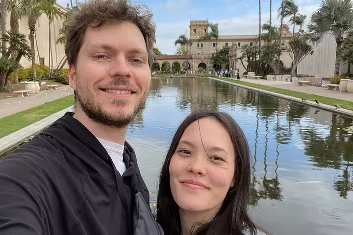 Couple taking selfie at Balboa Park reflecting pool with historic buildings in San Diego