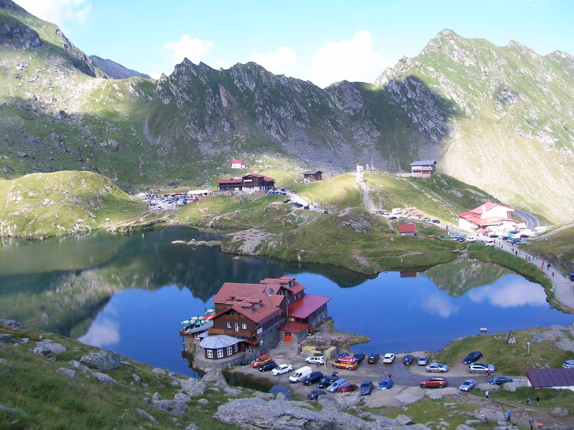 Aerial view of Balea Lake with alpine chalet and mountain reflections in Transylvania, Romania