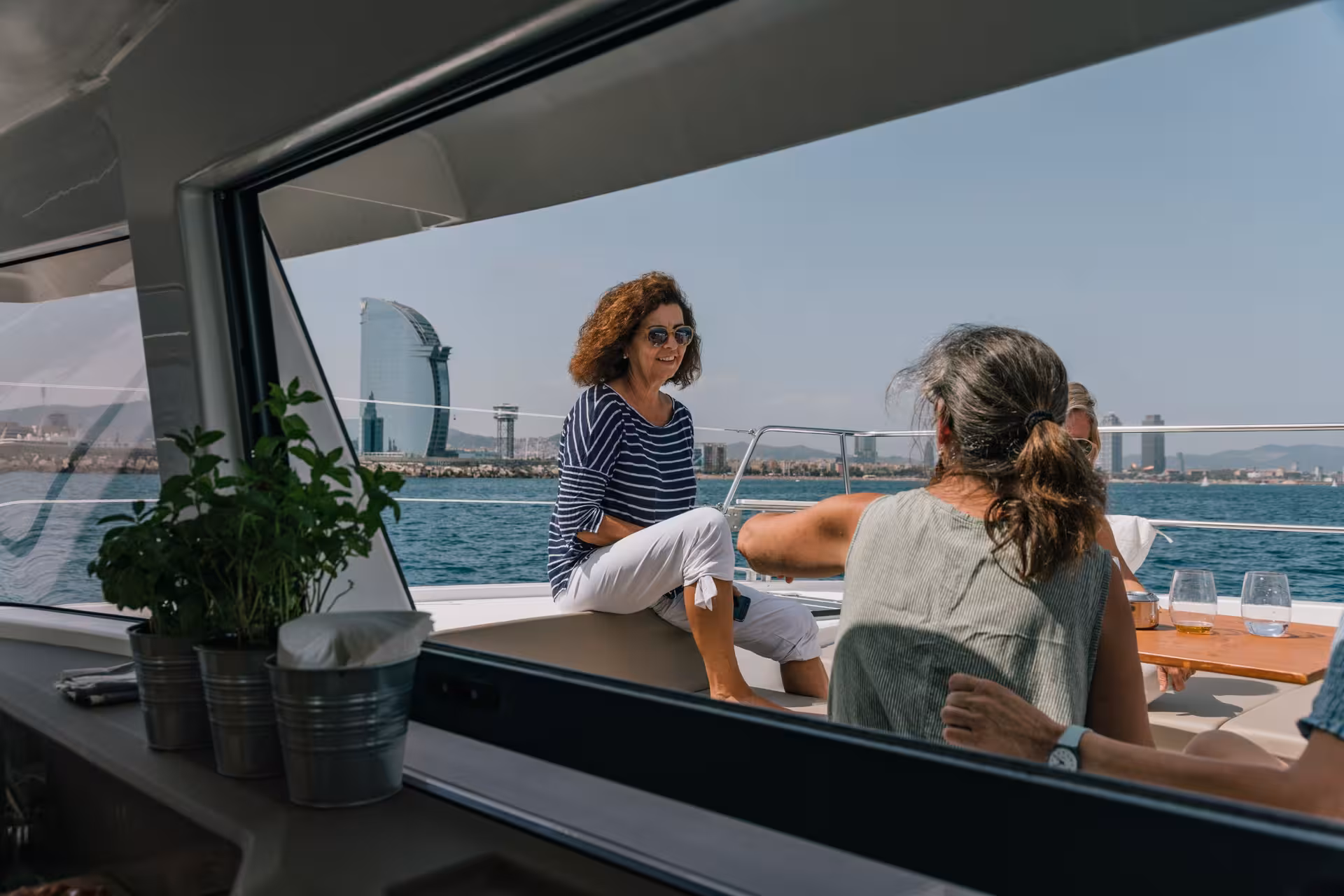 Guests relaxing on Bali 4.1 catamaran deck with Barcelona skyline on a 4-hour private luxury cruise