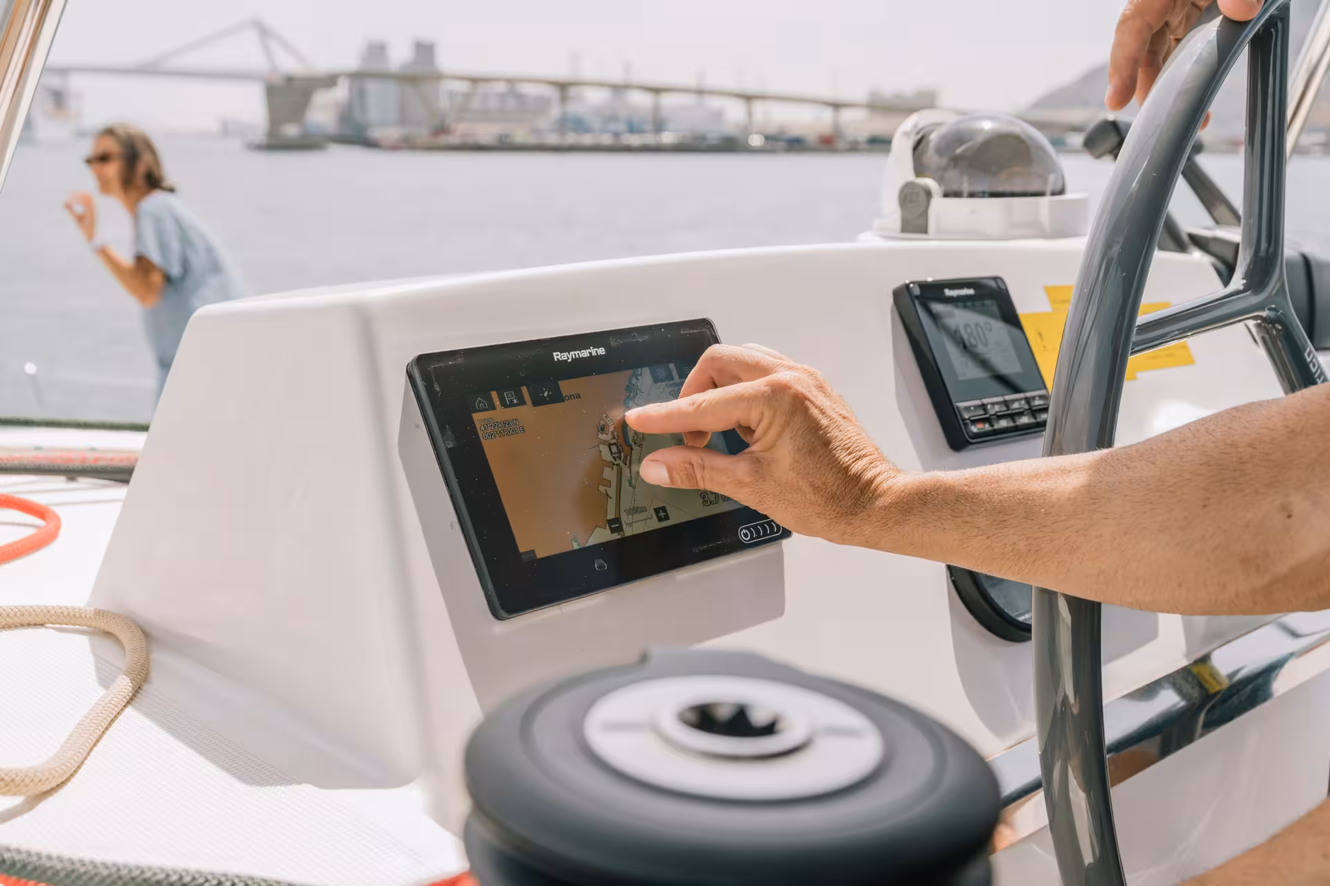 Skipper using GPS at helm on Bali 4.1 catamaran for a 2-hour private luxury sailing tour in Barcelona