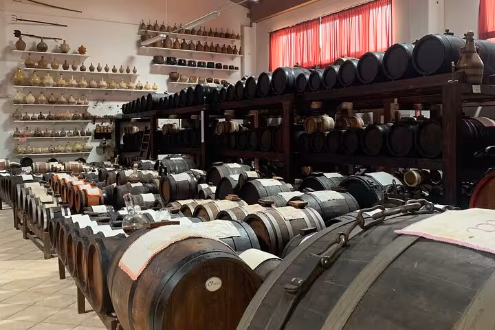 Rows of traditional barrels aging balsamic vinegar in a cellar, part of the Italian small group tour experience.