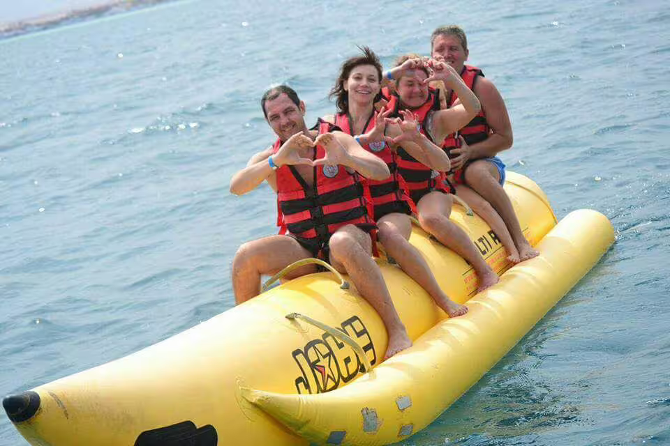 Friends riding a banana boat in Sharm El Sheikh, Red Sea, on a water sports adventure day trip